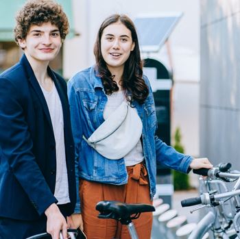 two young people at a bike share station